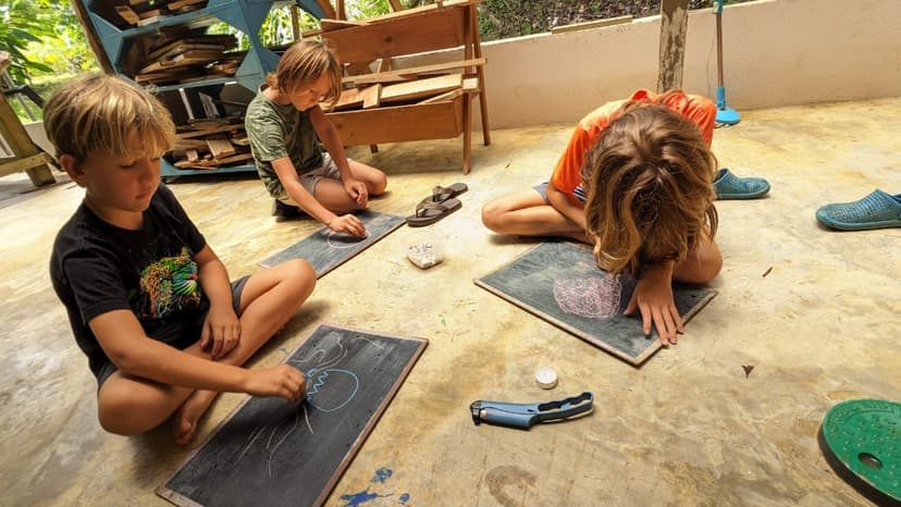 Children drawing with chalk on boards